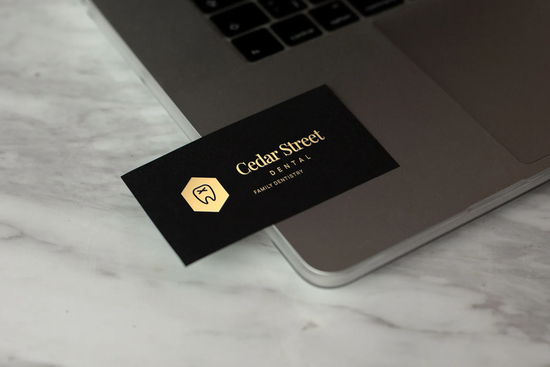Cedar Street Dental logo on black card on marble