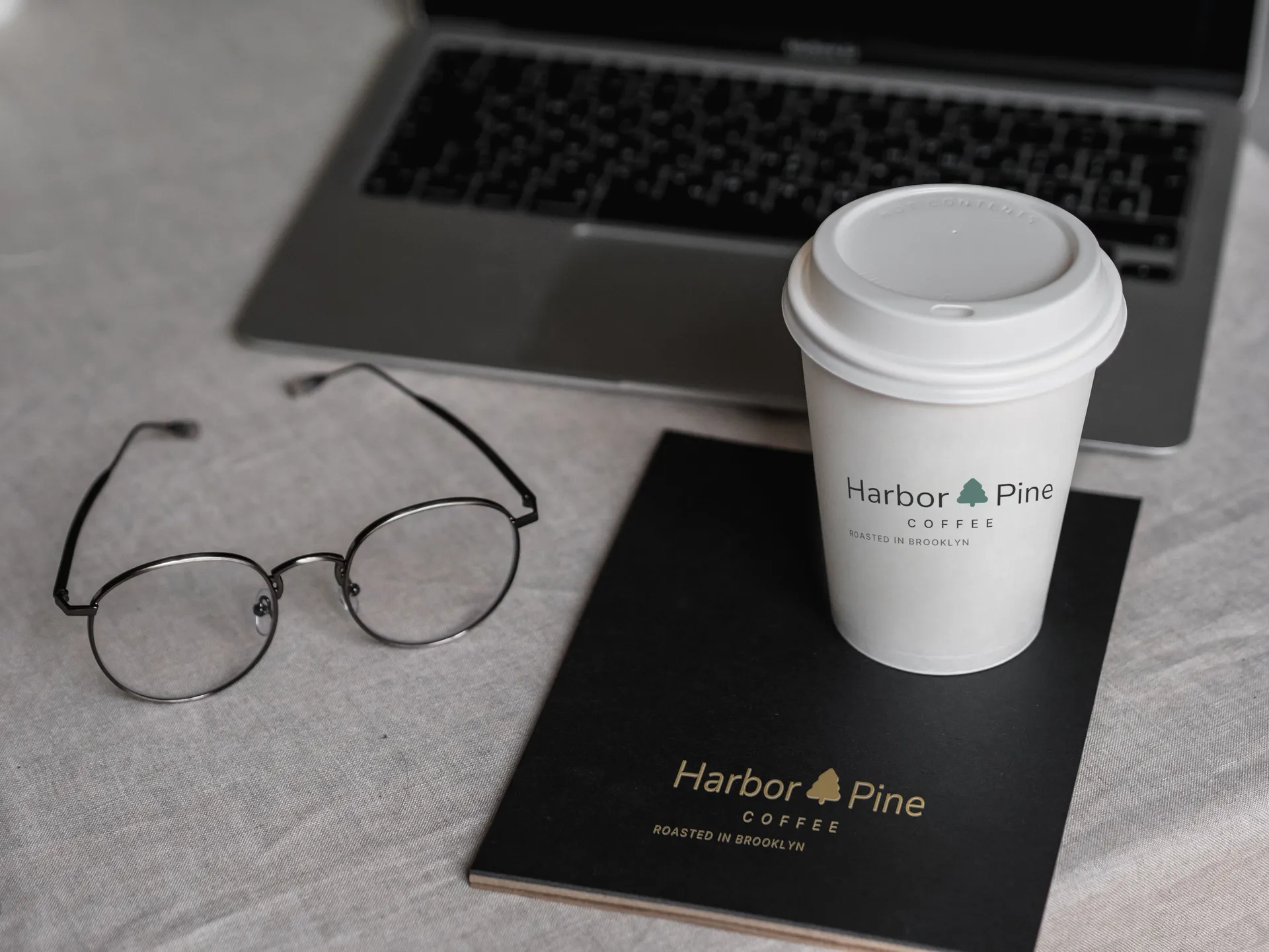 Harbor & Pine Coffee logo on takeaway cup on a desk