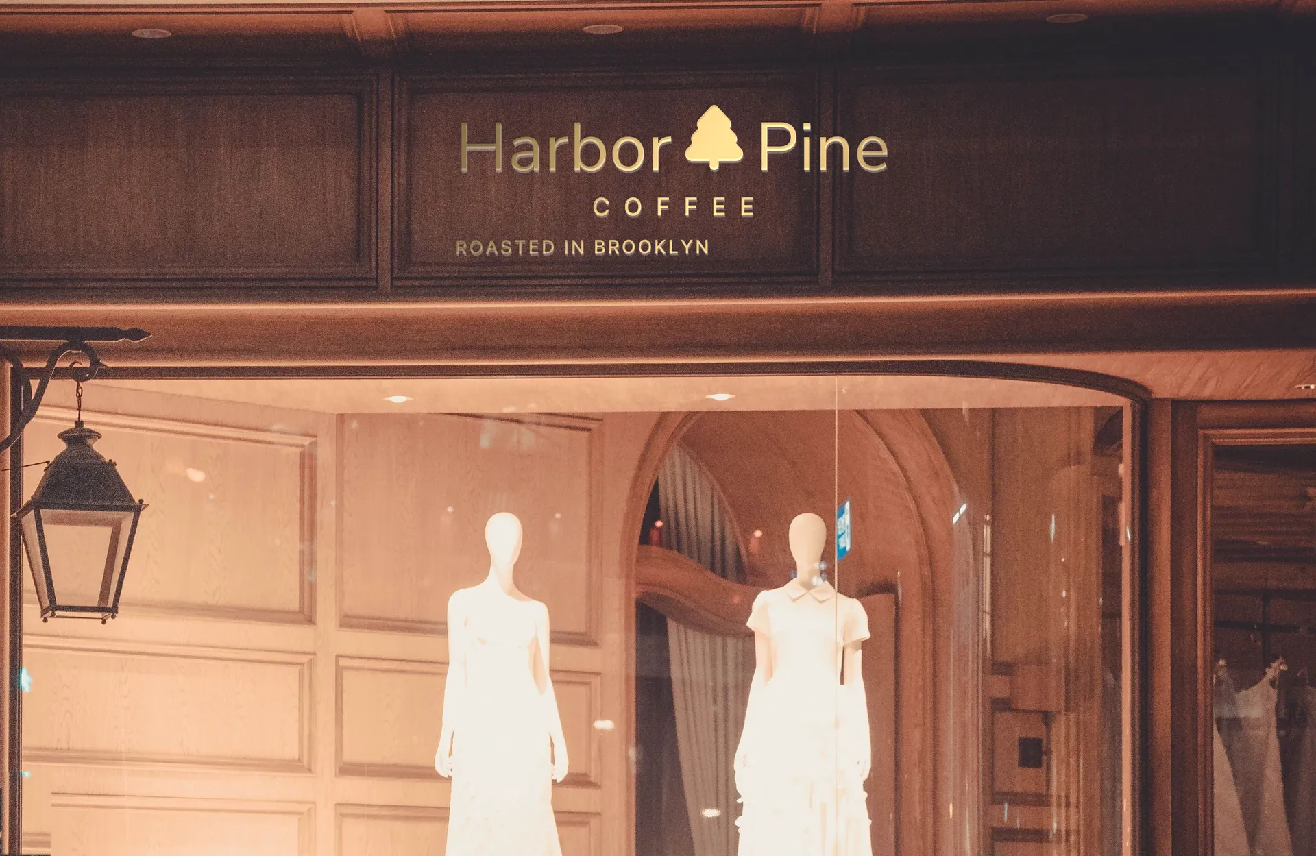 Harbor & Pine Coffee logo on flagship boutique at night