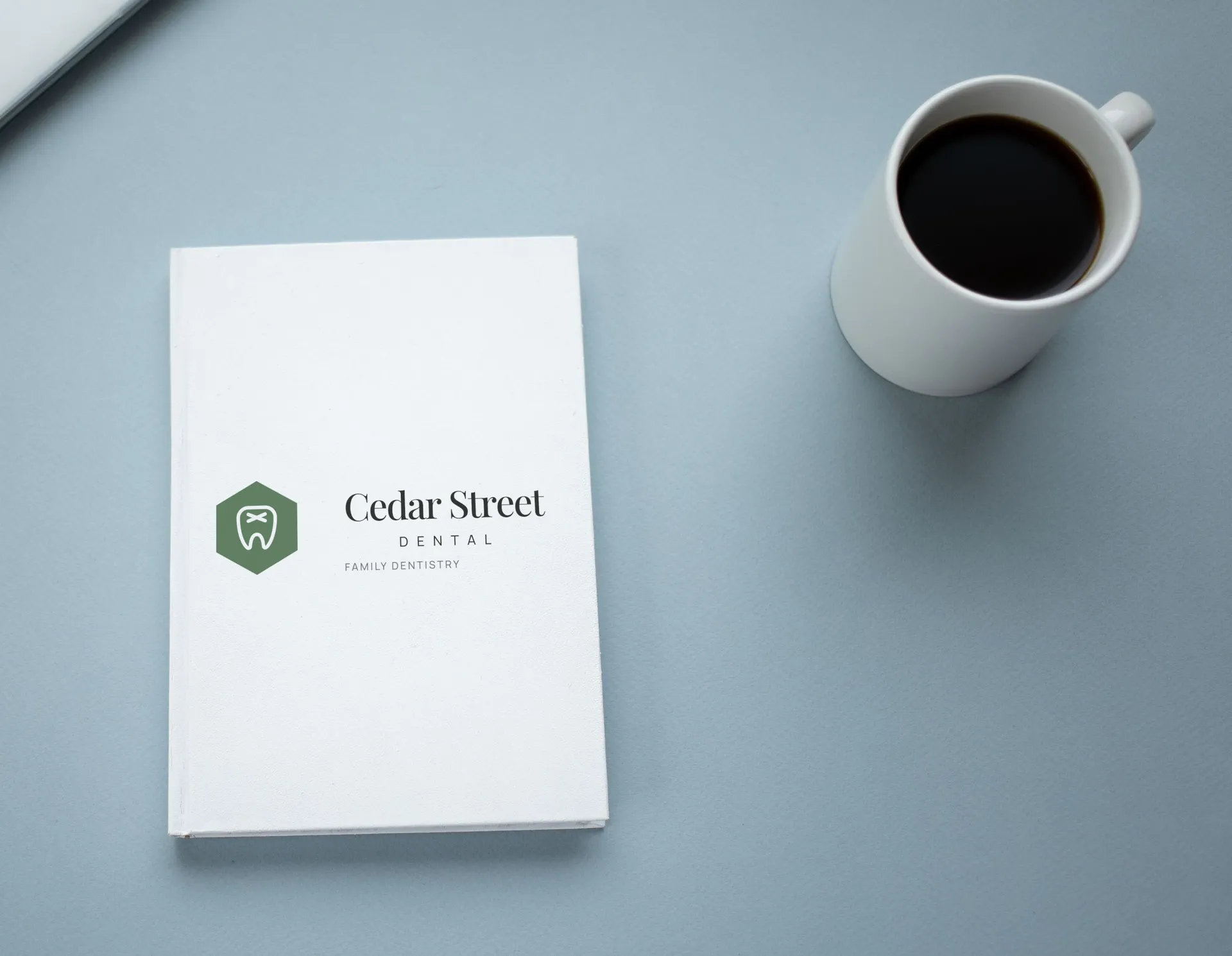 Cedar Street Dental logo on proposal cover with coffee